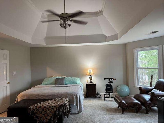 bedroom featuring ceiling fan, light colored carpet, and a raised ceiling