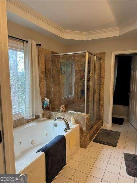 bathroom featuring crown molding, a tray ceiling, tile patterned floors, and plus walk in shower