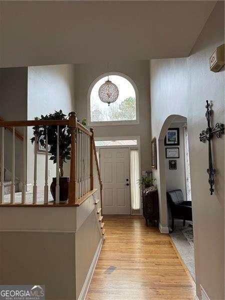 entryway with a towering ceiling and light hardwood / wood-style flooring