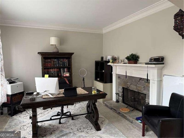 carpeted home office featuring crown molding and a stone fireplace