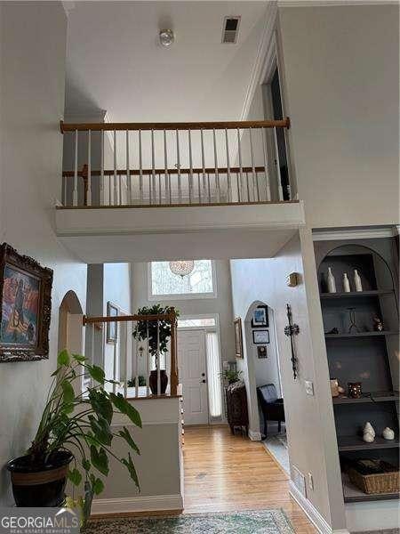 foyer entrance featuring a towering ceiling and hardwood / wood-style floors