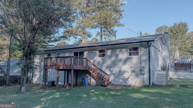 rear view of house with central AC unit, a deck, and a lawn