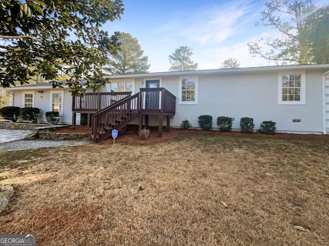 view of front of home featuring a wooden deck and a front yard