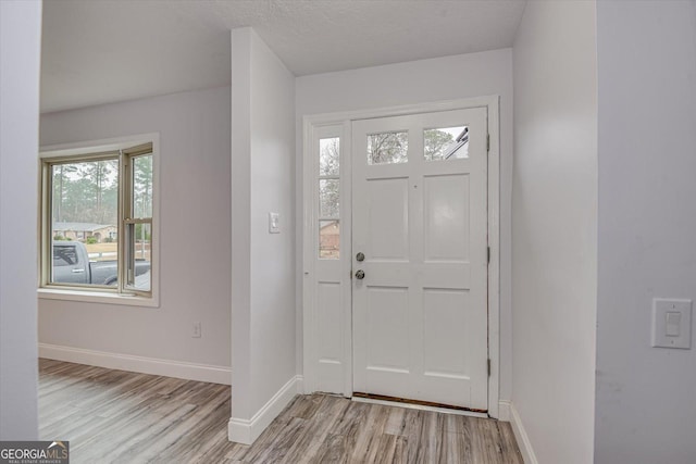 foyer with a textured ceiling and light hardwood / wood-style flooring