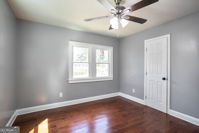 unfurnished room featuring dark wood-type flooring and ceiling fan