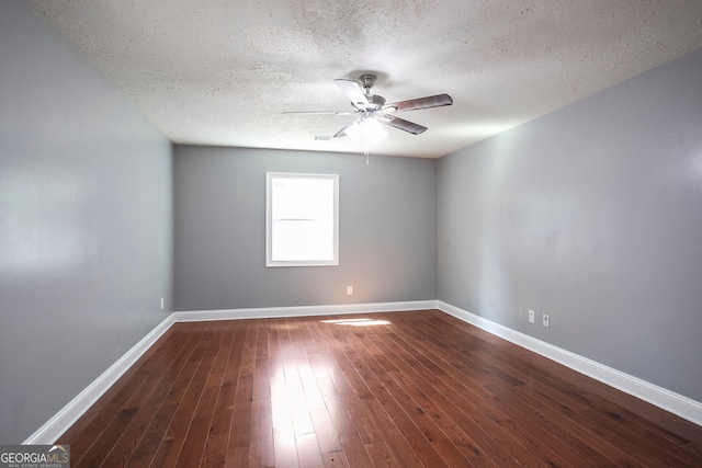 empty room with a textured ceiling, dark hardwood / wood-style floors, and ceiling fan