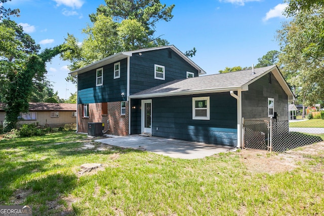 rear view of property with a yard, a patio, and central air condition unit