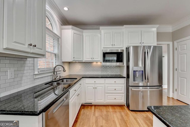 kitchen with stainless steel appliances, ornamental molding, sink, and white cabinets