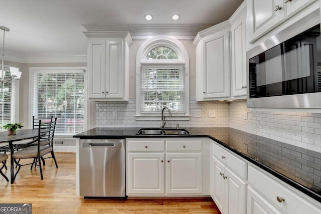 kitchen with built in microwave, sink, white cabinetry, and dishwasher