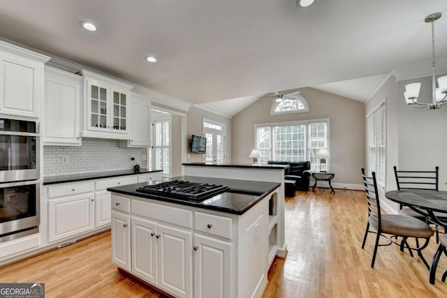 kitchen with lofted ceiling, light hardwood / wood-style flooring, white cabinetry, hanging light fixtures, and stainless steel double oven