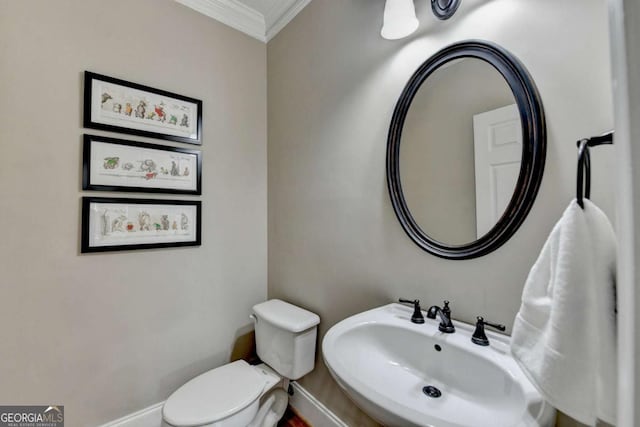 bathroom featuring ornamental molding, sink, and toilet