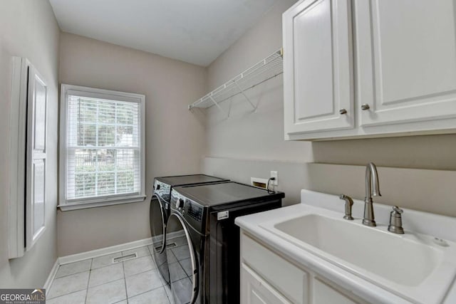 clothes washing area featuring cabinets, washing machine and dryer, sink, and light tile patterned floors