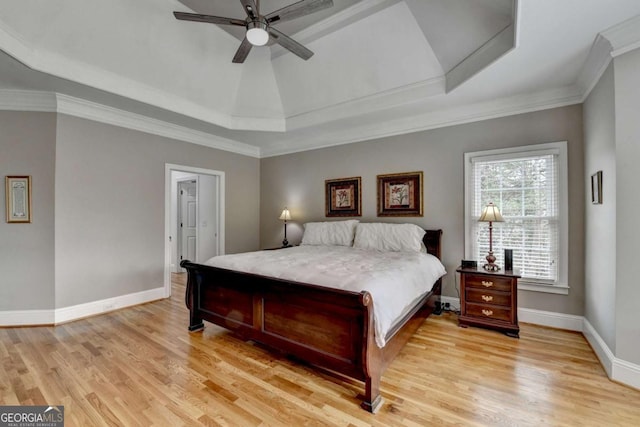 bedroom featuring crown molding, light hardwood / wood-style floors, a raised ceiling, and ceiling fan