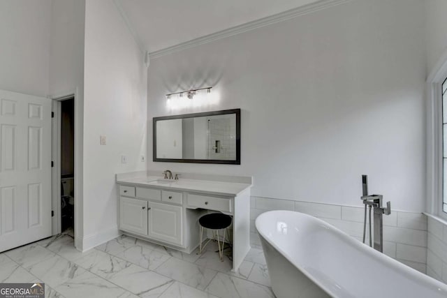 bathroom featuring crown molding, a bath, and vanity