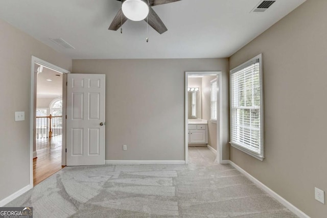 unfurnished bedroom with light carpet, ceiling fan, and ensuite bathroom