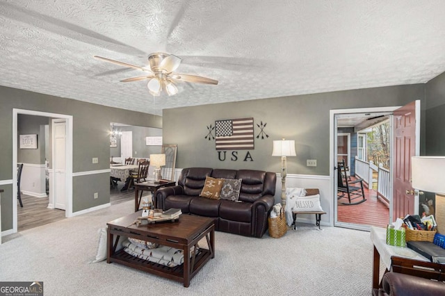 carpeted living room with a textured ceiling and ceiling fan