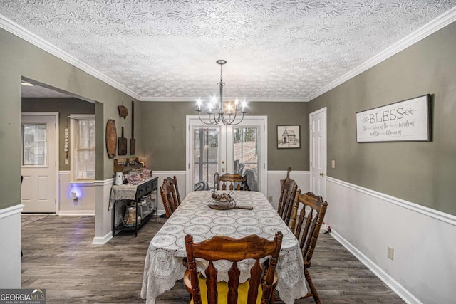 dining area featuring an inviting chandelier, ornamental molding, dark hardwood / wood-style floors, and a textured ceiling