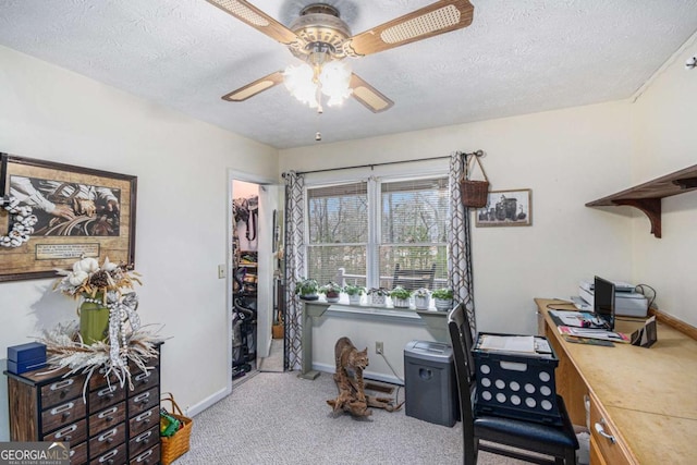 carpeted office space with ceiling fan and a textured ceiling