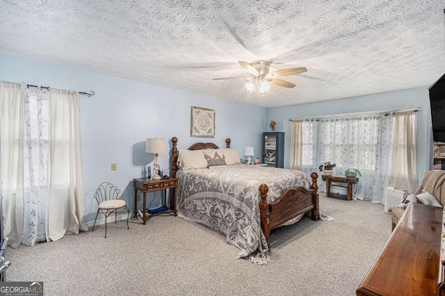 carpeted bedroom featuring a textured ceiling and ceiling fan