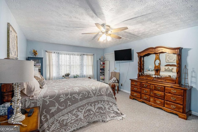 carpeted bedroom with a textured ceiling and ceiling fan