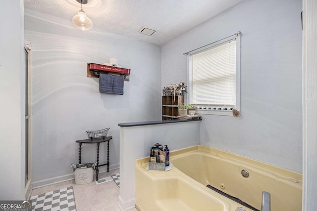 bathroom featuring a textured ceiling and a bathing tub