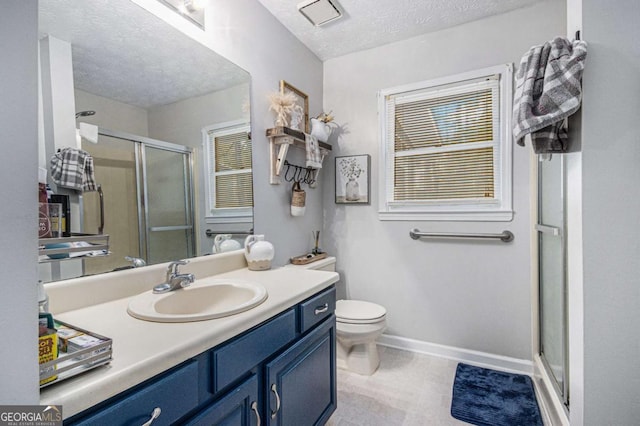 bathroom featuring vanity, an enclosed shower, a textured ceiling, and toilet