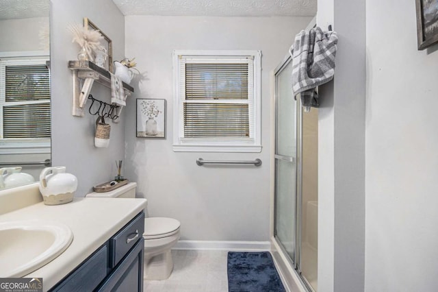 bathroom featuring vanity, toilet, a shower with shower door, and a textured ceiling