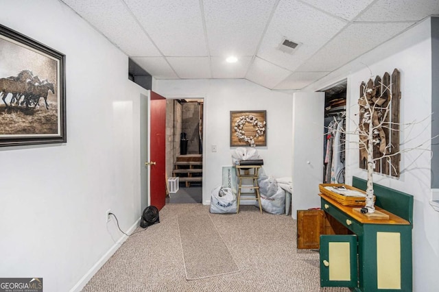 hallway with a paneled ceiling and carpet floors