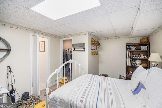 bedroom featuring carpet floors and a drop ceiling