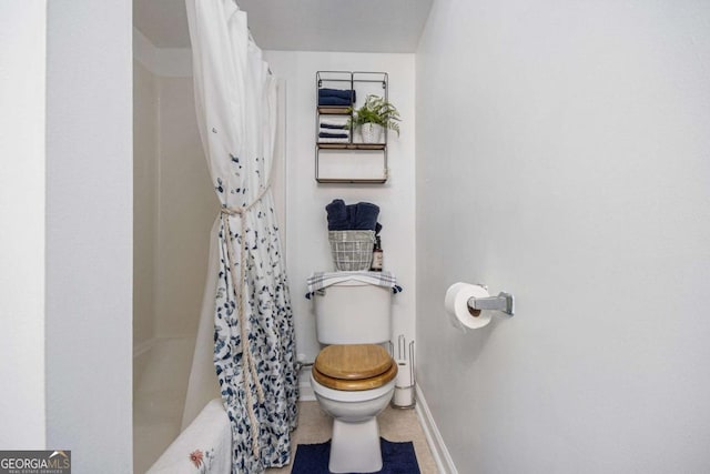 bathroom featuring shower / tub combo and toilet