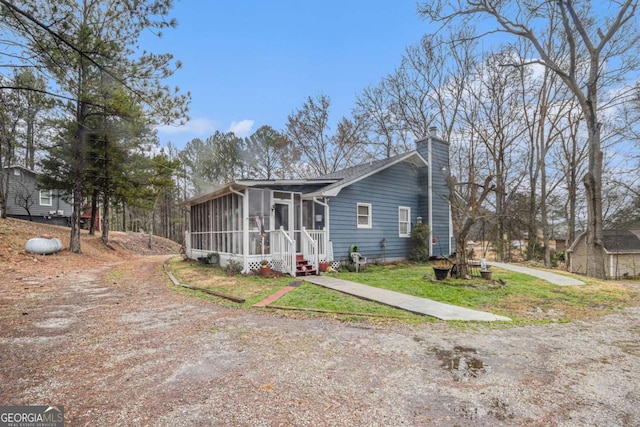 view of front facade with a sunroom and a front yard