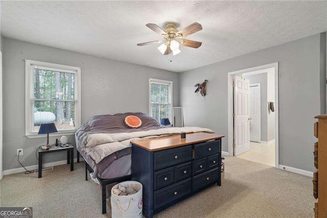 carpeted bedroom with ceiling fan, multiple windows, and a textured ceiling