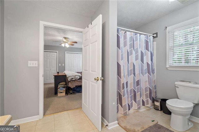 bathroom with ceiling fan, curtained shower, toilet, and a textured ceiling