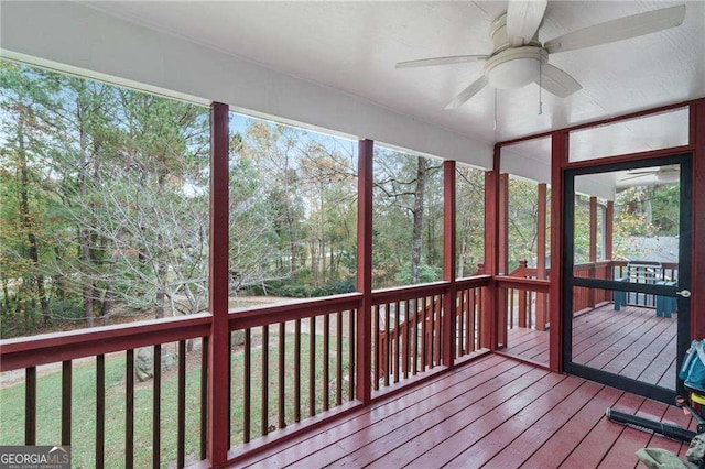 unfurnished sunroom featuring ceiling fan