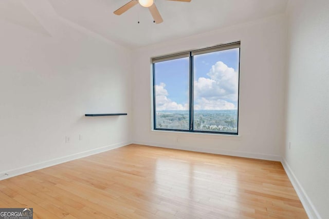 spare room with ceiling fan, wood finished floors, and baseboards