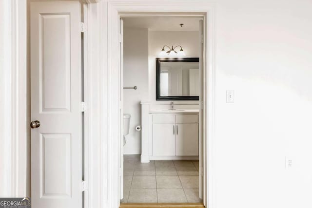 corridor featuring light tile patterned flooring and a sink