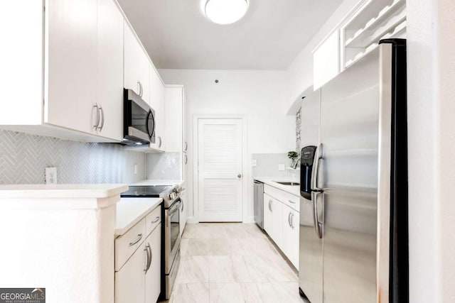 kitchen featuring white cabinets, appliances with stainless steel finishes, light countertops, and backsplash