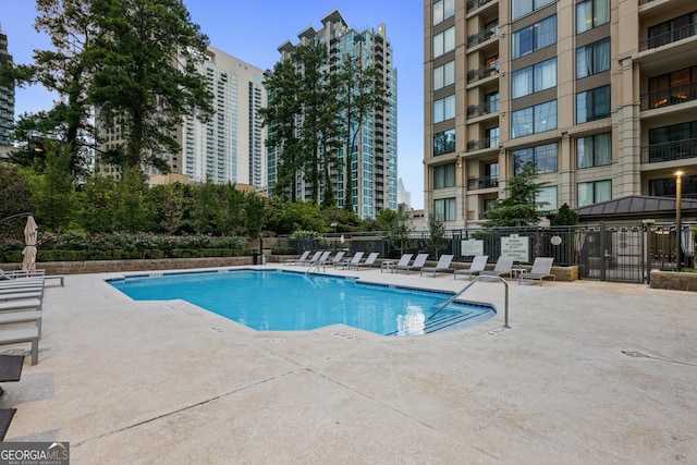 pool featuring fence and a patio