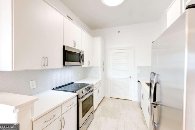 kitchen featuring light countertops, appliances with stainless steel finishes, white cabinets, and tasteful backsplash