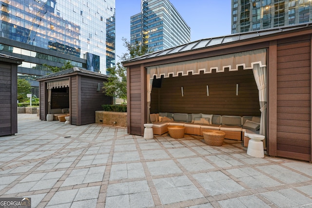 view of patio featuring an outdoor hangout area, an outbuilding, and a view of city