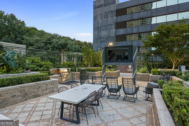 view of patio / terrace with outdoor dining area, an outdoor kitchen, a grill, and fence