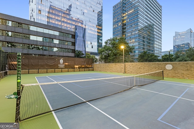 view of sport court featuring community basketball court, a view of city, and fence