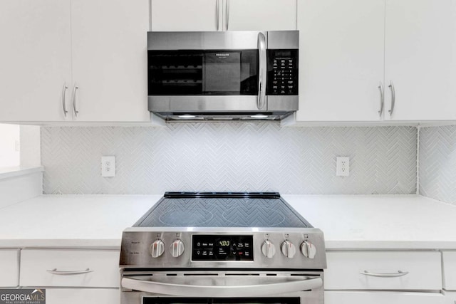 kitchen with stainless steel appliances, light countertops, and white cabinets