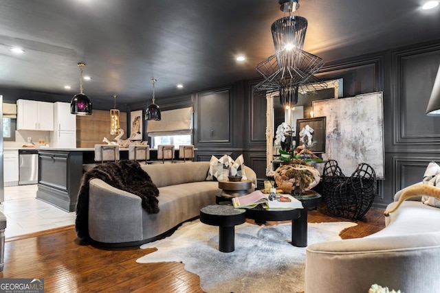 living area featuring light wood-style flooring, a decorative wall, and recessed lighting