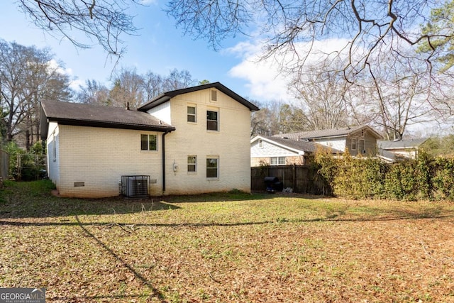 rear view of house featuring a lawn and central air condition unit