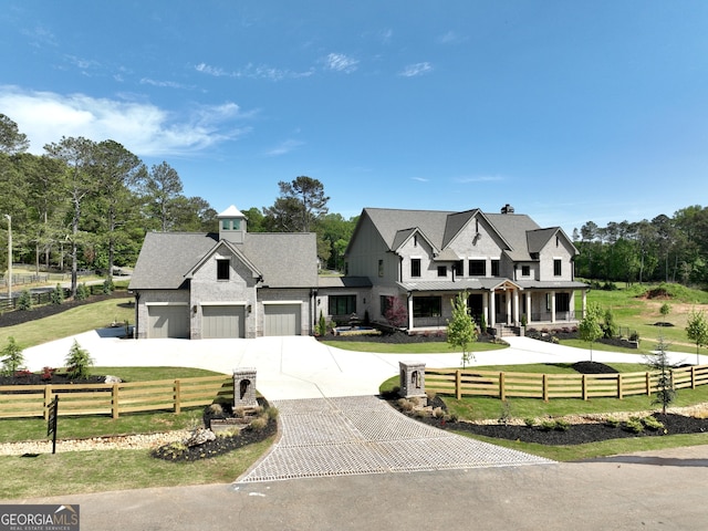 modern farmhouse with a standing seam roof, fence, curved driveway, and a front yard