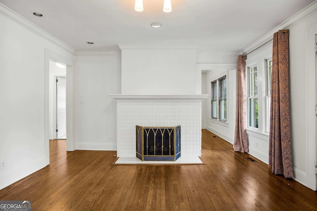 unfurnished living room featuring a brick fireplace, dark hardwood / wood-style flooring, and ornamental molding