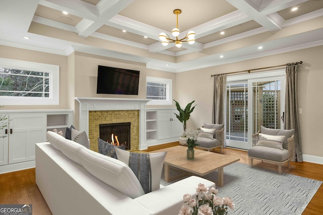 living room with beam ceiling, coffered ceiling, dark wood finished floors, a fireplace, and a chandelier