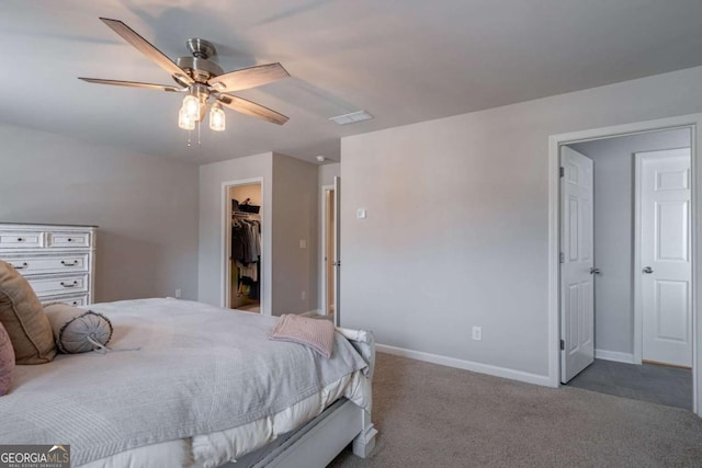 carpeted bedroom featuring ceiling fan, a spacious closet, and a closet