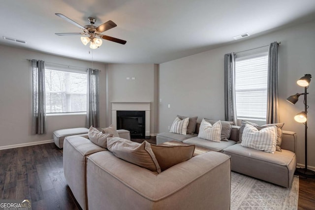 living room featuring dark wood-type flooring and ceiling fan